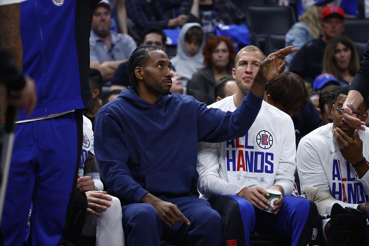 Clippers star Kawhi Leonard sits on the bench in street clothes during Game 1 on Sunday.