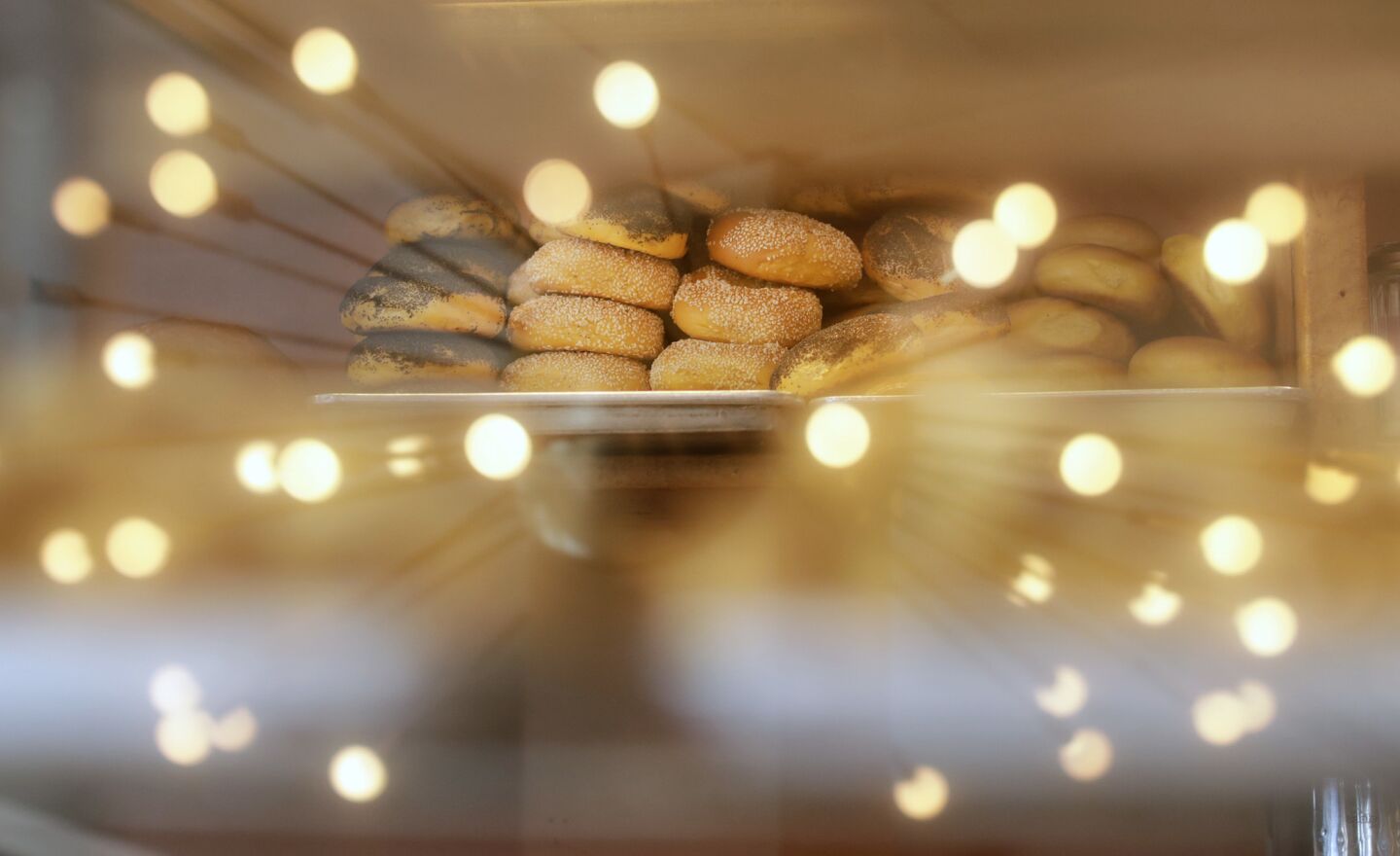 A vintage light is reflected in a display of bagels at Canter's.