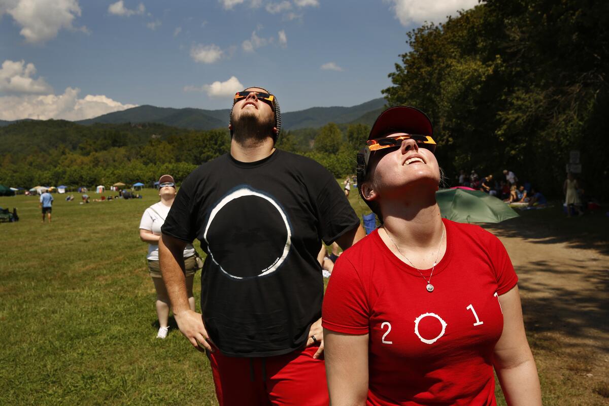Conner and Ellie Meyer of Atlanta watch as the total solar eclipse begins over Andrews, N.C., on Aug. 21, 2017. 