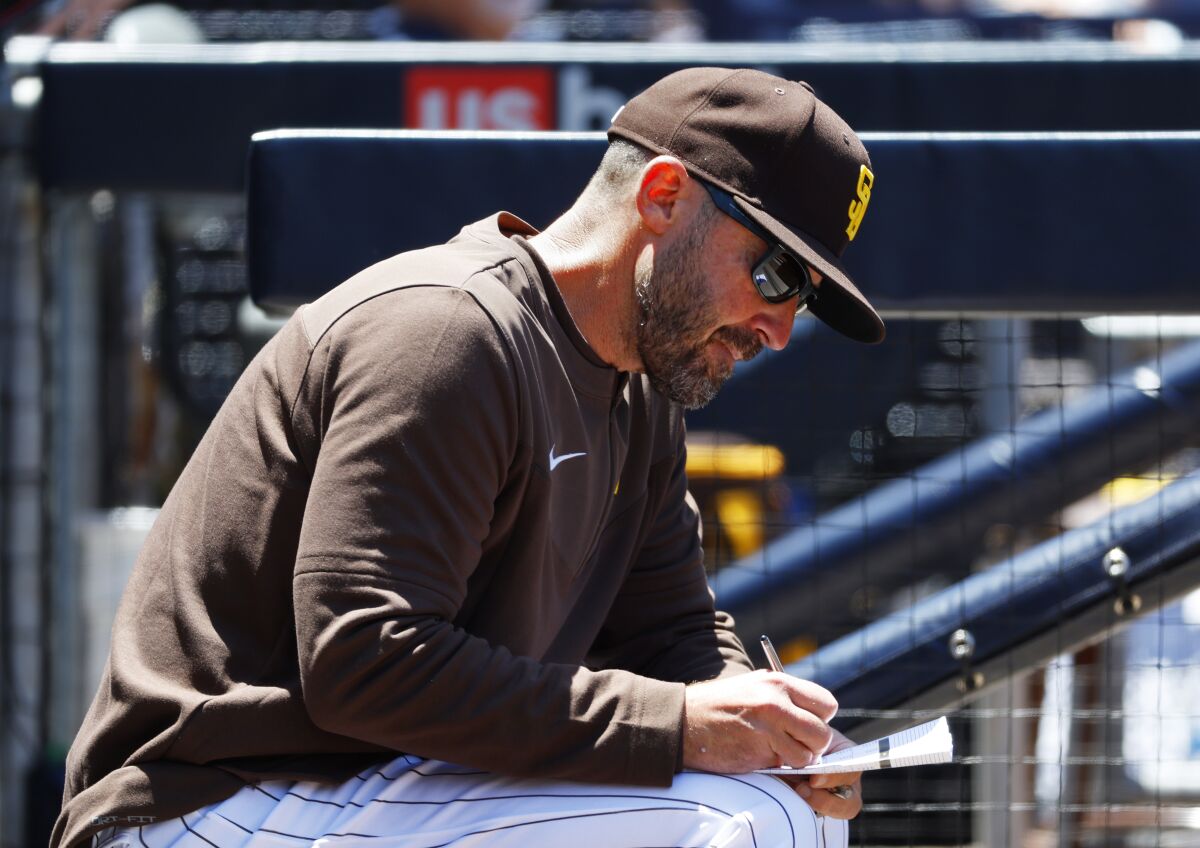 Padres acting manager Ryan Christenson makes notes during Wednesday's game against the Cubs.