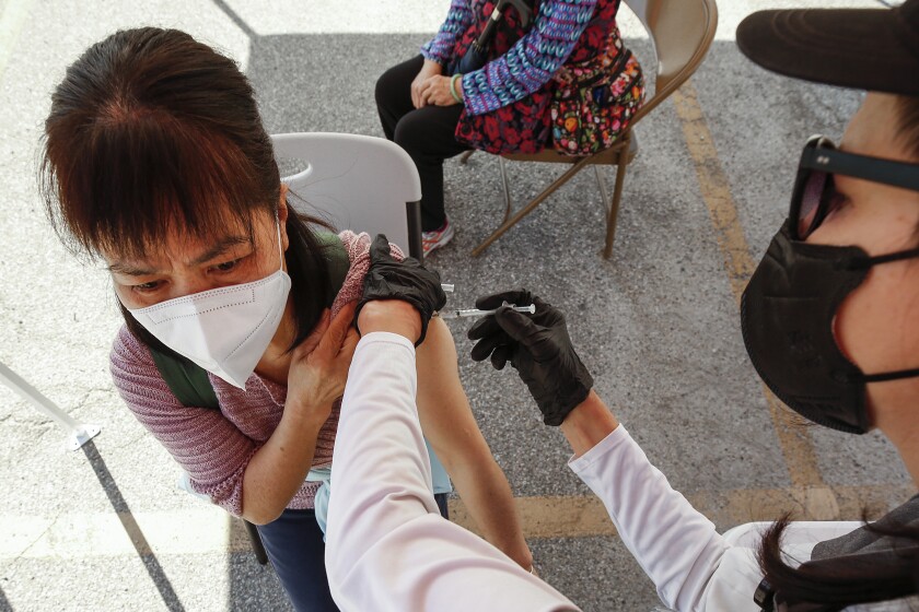 LOS ANGELES, CA - FEBRUARY 24: A person receives the Pfizer COVID-19 vaccine from registered nurse Cristy Michel as the LA City CORE mobile team is staging a COVID-19 vaccination clinic in Chinatown for senior citizens, in an attempt to improve access to the vaccine among vulnerable populations. Chinatown on Wednesday, Feb. 24, 2021 in Los Angeles, CA. (Al Seib / Los Angeles Times).