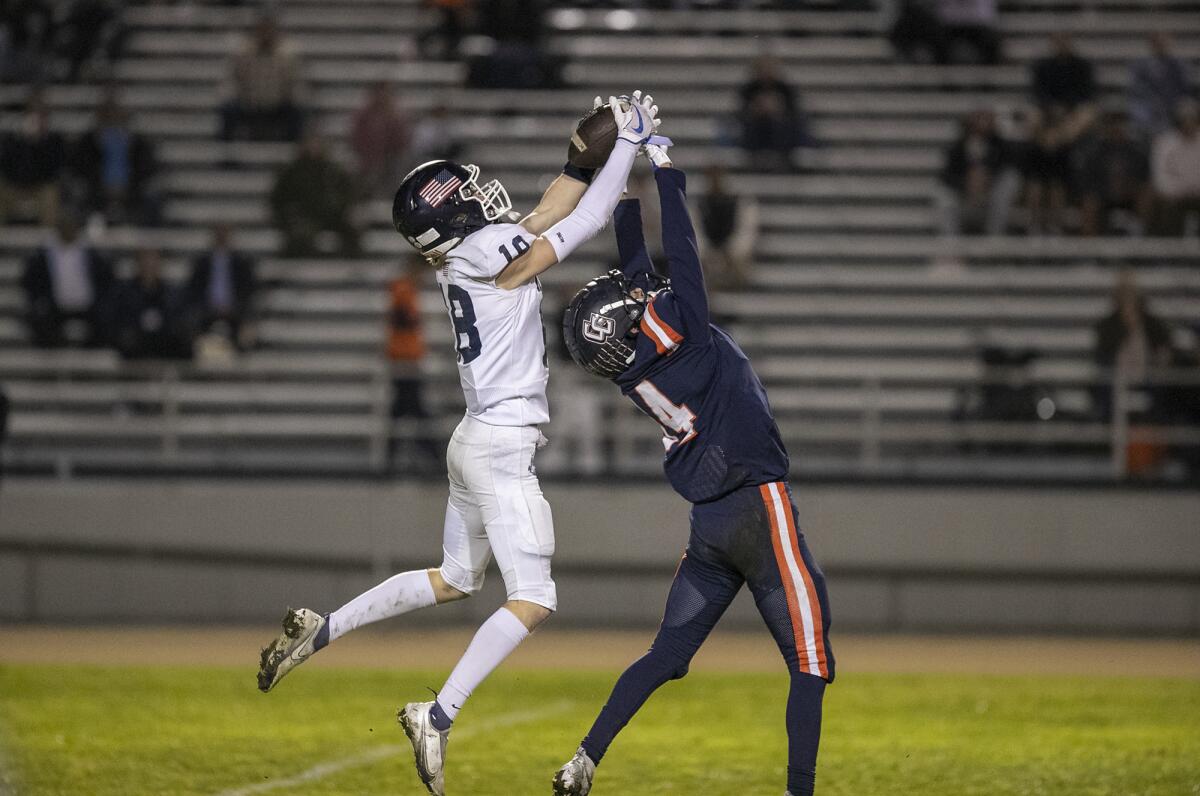 Newport Harbor's Tommy Robinson makes a catch over Cypress' Bobby Castillo during a CIF Division 4 semifinal game on Friday.
