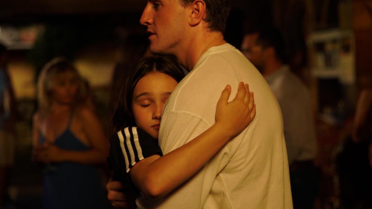 A girl hugs her father in a scene from the movie "Aftersun."