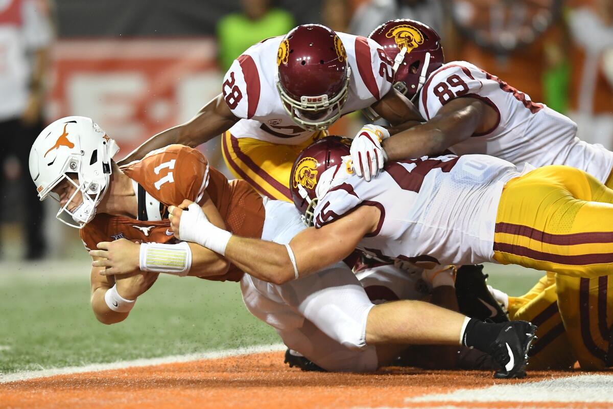 Texas quarterback Sam Ehlinger appears to be sacked in the end zone by USC's C.J. Pollard (28), Christian Rector (89) and Porter Gustin, but the ball was ruled down at the one-yard line in the second quarter at Texas on Saturday.