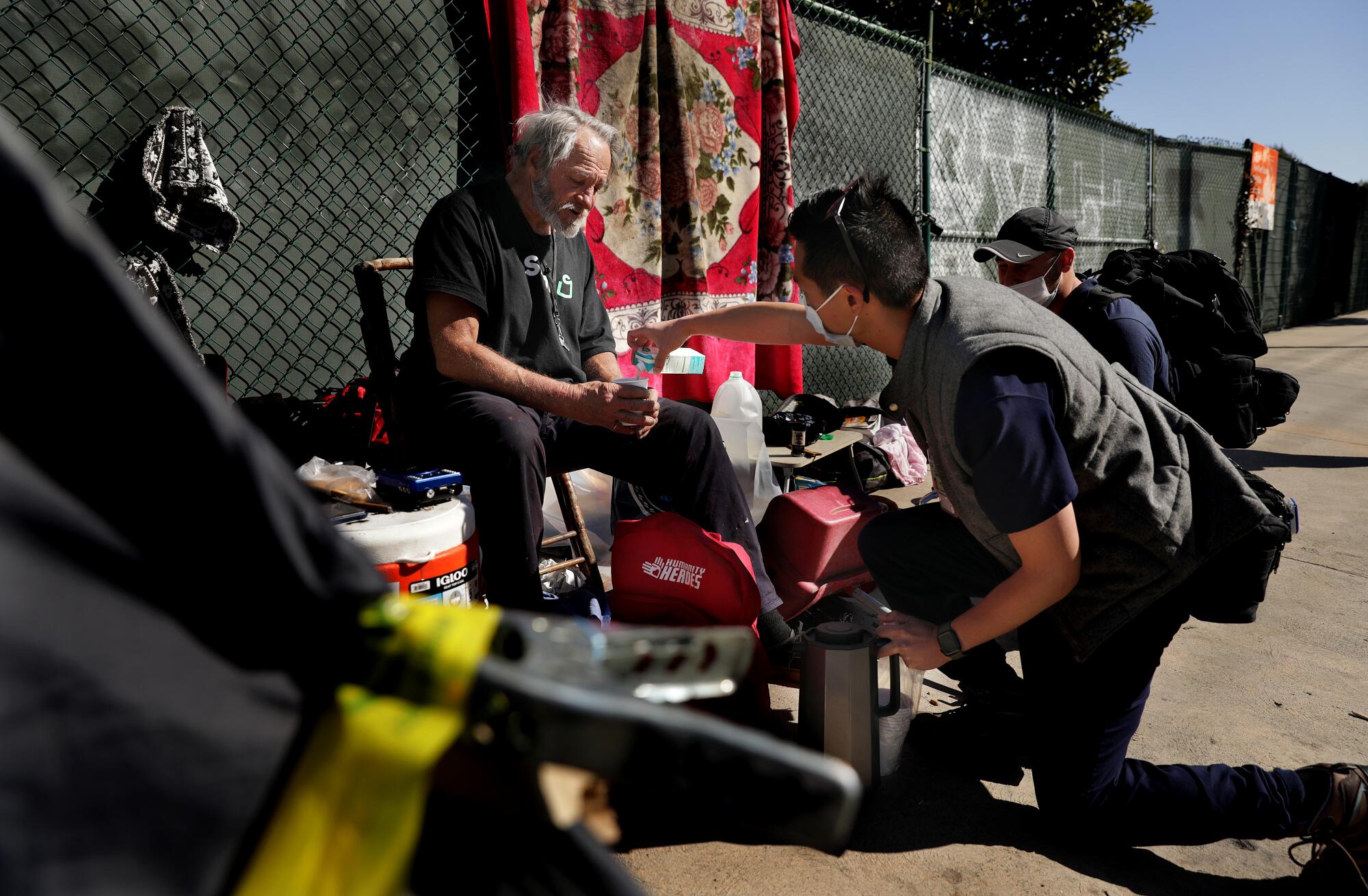 EMT Christopher Phan makes a cup of coffee for Terry Mason Kendrick as the medical team visits Van Nuys on March 7, 2022.