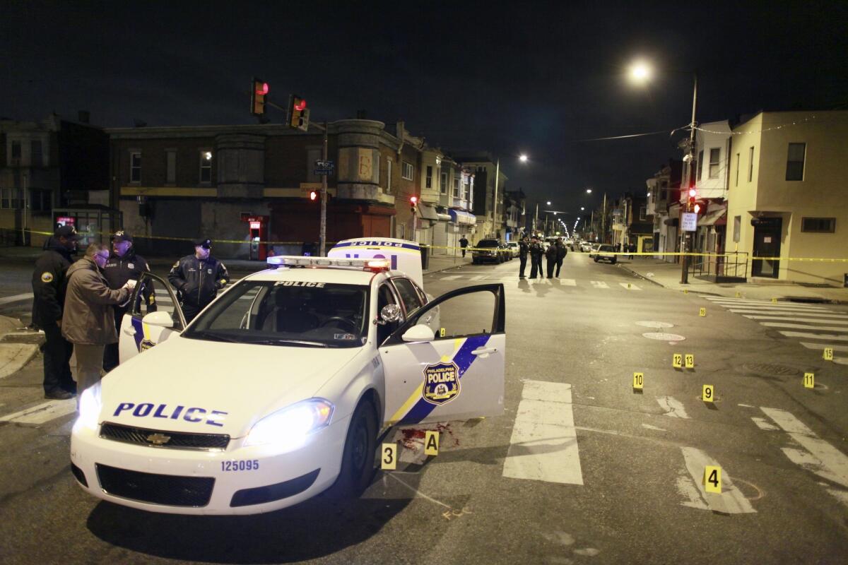 Officers investigate after a police officer was injured in an ambush in Philadelphia.