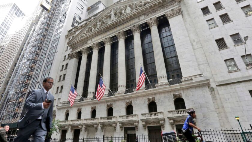 People pass the New York Stock Exchange.