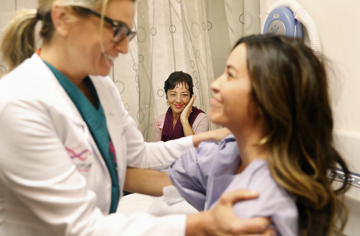 Cecilia Medellin, center, looks on as Dr. Kristi Funk talks with Alejandra Campoverdi before the surgery. (Christina House / Los Angeles Times)