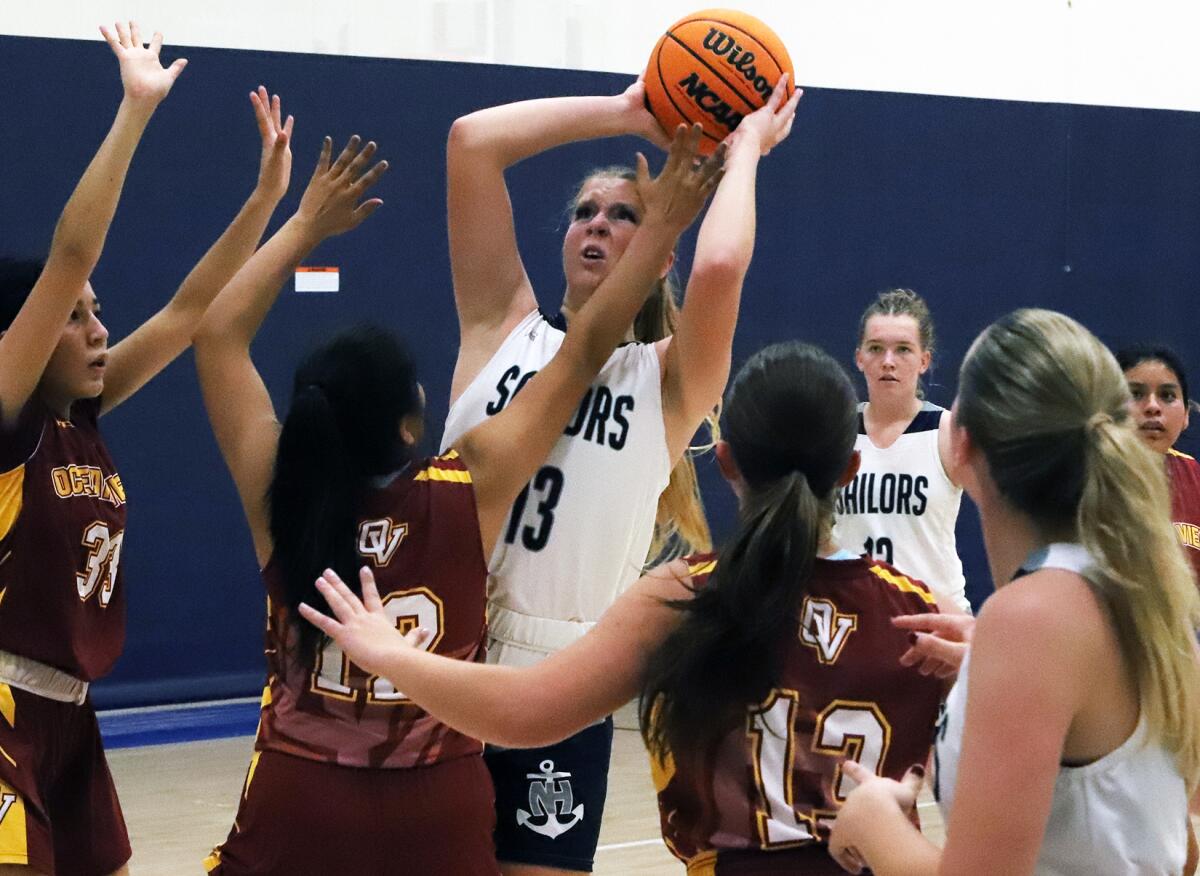 Newport Harbor's Kaitlyn Leibe (13) tries to shoot over Ocean View defenders in the Pacifica Mariner Mayhem Tournament.