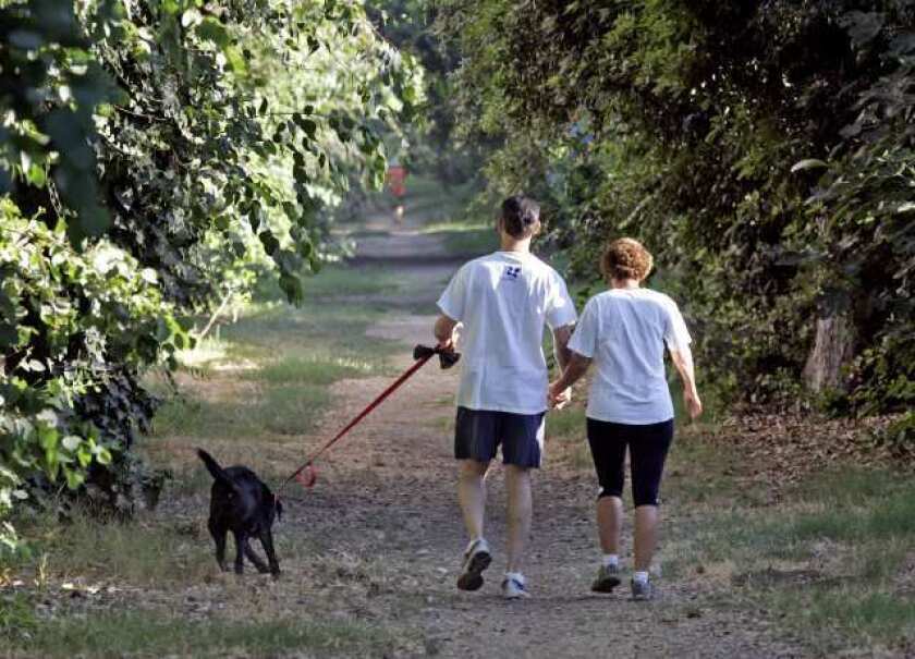 ARCHIVE PHOTO: A couple walk hand in hand with their dog on the horse trail north of Foothill Boulevard, east of St. Bede the Venerable Church early in the morning on Thursday, August 19, 2010. The trail leads to the northern parts of La Canada Flintridge.