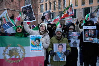 a demonstration in Berlin with people holding images of different individuals