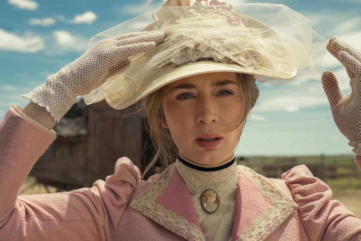 An aristocratic woman in a pink coat and white hat on the prairie