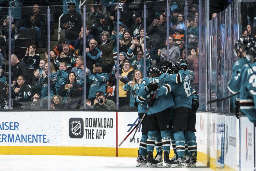 FILE - In this Dec. 28, 2019, file photo, San Jose Sharks right wing Timo Meier is embraced by teammates as they celebrates after his first goal of the game during the second period of an NHL hockey game against the Philadelphia Flyers in San Jose, Calif. The Sharks and the NHL are still determining how to proceed with three scheduled games in San Jose this month following a local ban put in place on large gatherings of more than 1,000 people in response to the spread of the new coronavirus. (AP Photo/John Hefti, File)