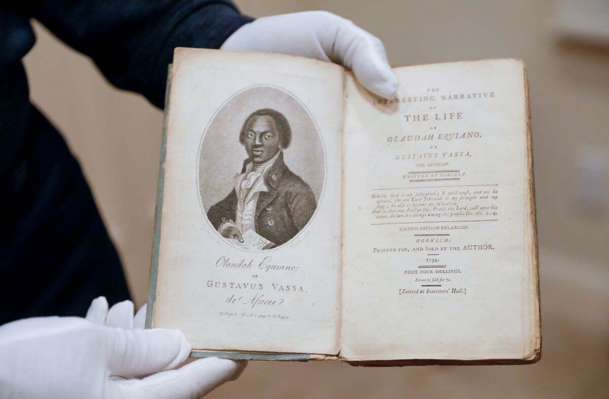 Bernard Kinsey wears gloves to handle a rare work from their collection.