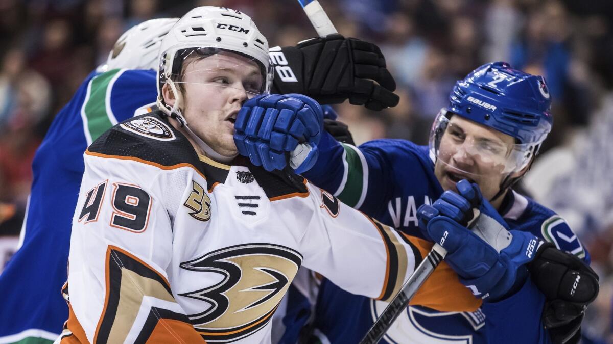 Ducks' Max Jones, left, and Vancouver Canucks' Luke Schenn get into a scuffle during the third period.