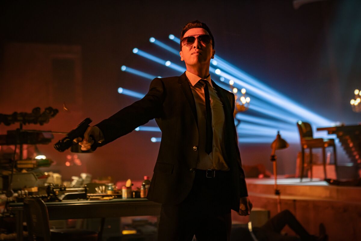 man in sunglasses inside holds out a gun
