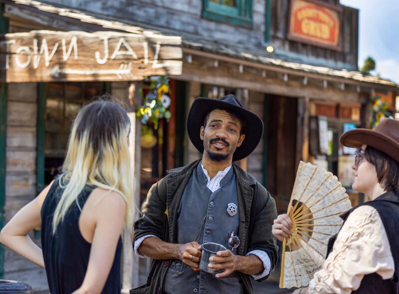 Visitors talk with Evan Battle, center, who plays Deputy Chester Davenport.