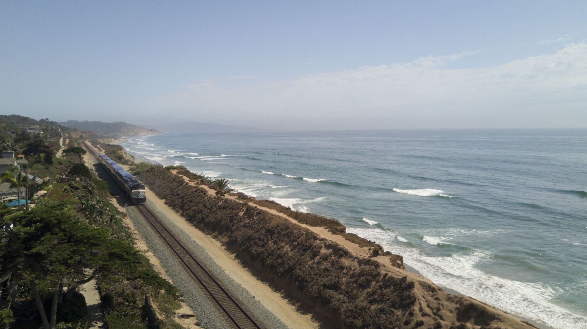 A Surfliner train by Amtrak travels along the collapsing bluffs in Del Mar.
