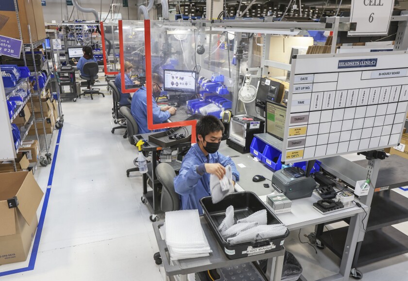 Trabajadores de HM Electronics en Carlsbad fabrican auriculares inalámbricos 