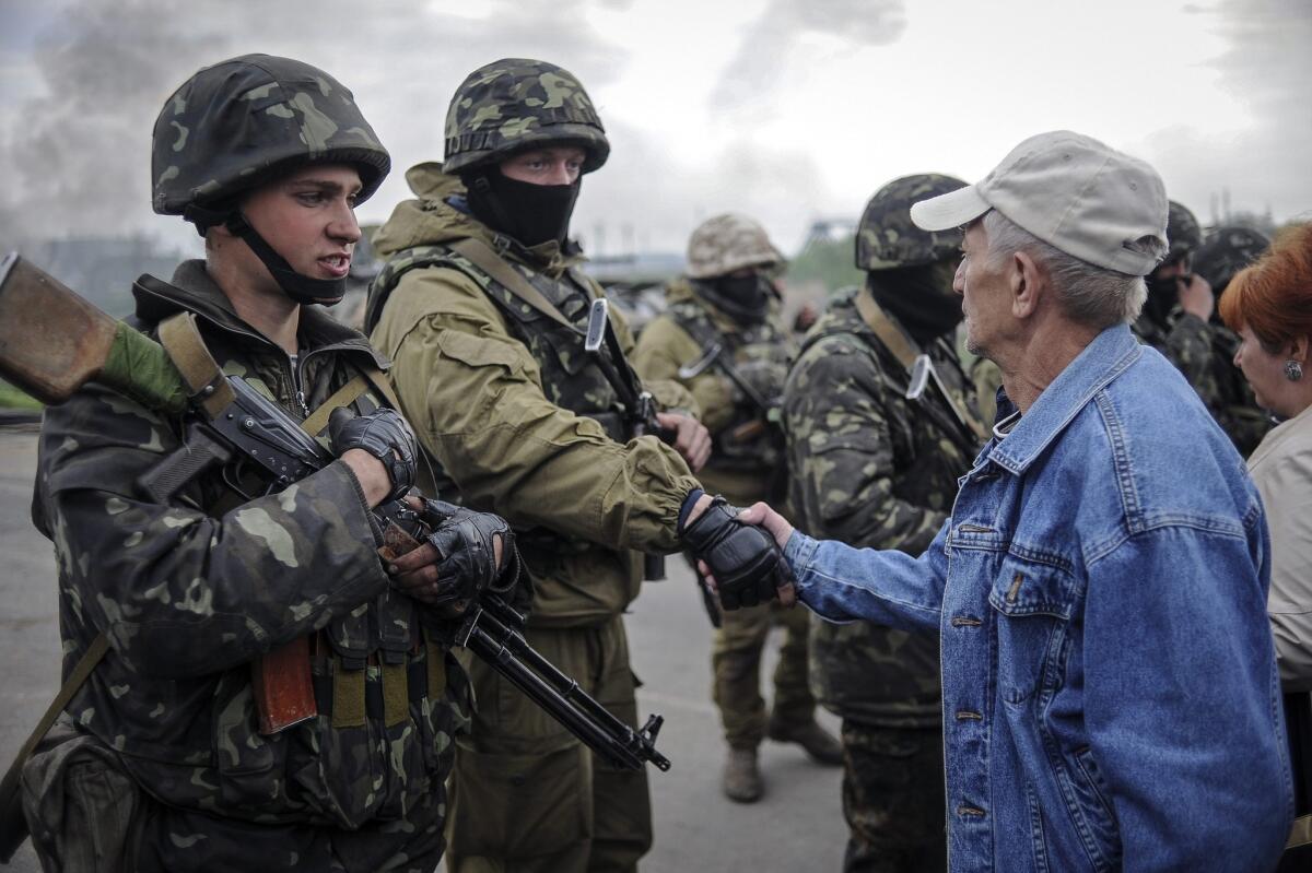 A resident speaks with Ukrainian soldiers near a checkpoint that they seized not far from Slovyansk.