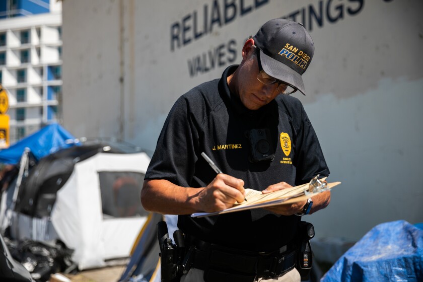 San Diego Police Officers Jeff Martinez writes a reduced-cost voucher for homeless resident.