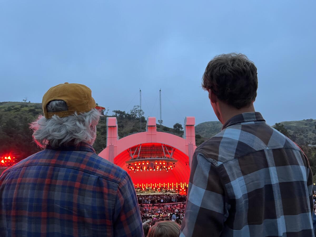 The view of two men in plaid shirts from the back looking at the Hollywood Bowl.