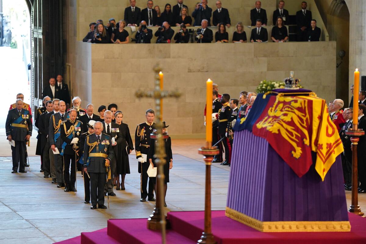 FILE - Photographers and reporters can be seen in background, upper right, with the coffin of Queen Elizabeth II on the catafalque in Westminster Hall, London, Wednesday Sept. 14, 2022. Plans by news organizations that have been in place for years — even decades — to cover the death of Queen Elizabeth II were triggered and tested when the event took place. London has been inundated with journalists, with more headed to the city for the funeral services on Monday. ( Jacob King/Pool via AP, File)