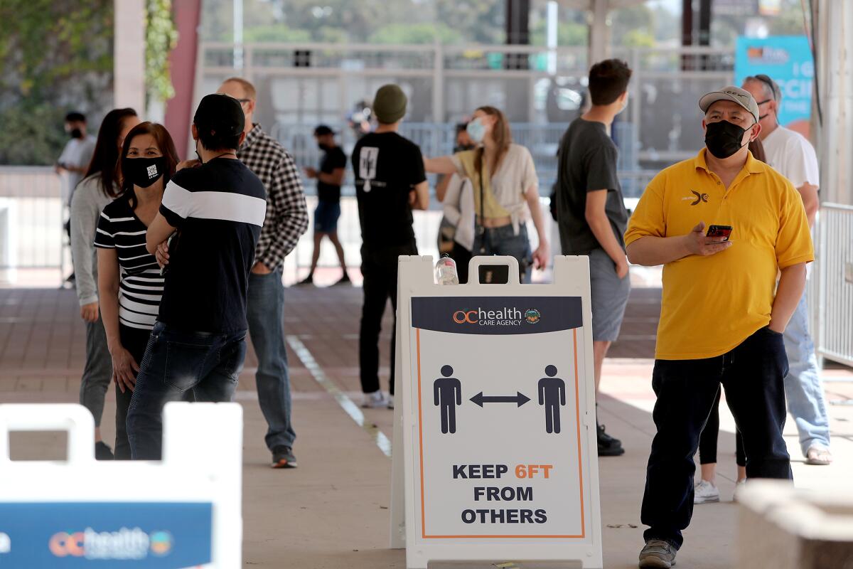 Appointment holders wait in line at a COVID-19 vaccination site in Costa Mesa.