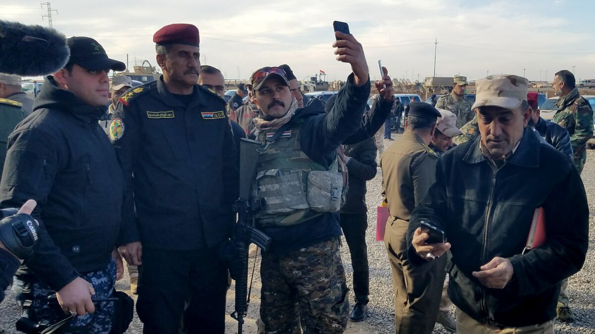 Lt. Gen. Abdel Wahab Saadi, Iraqi Special Forces commander, center, does not have a Facebook account but has posed for enough selfies that troops recognize him - and request more.