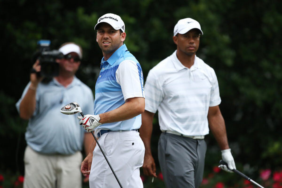 Sergio Garcia and Tiger Woods watch the result of a drive by Garcia during the third round of the Players Championship.