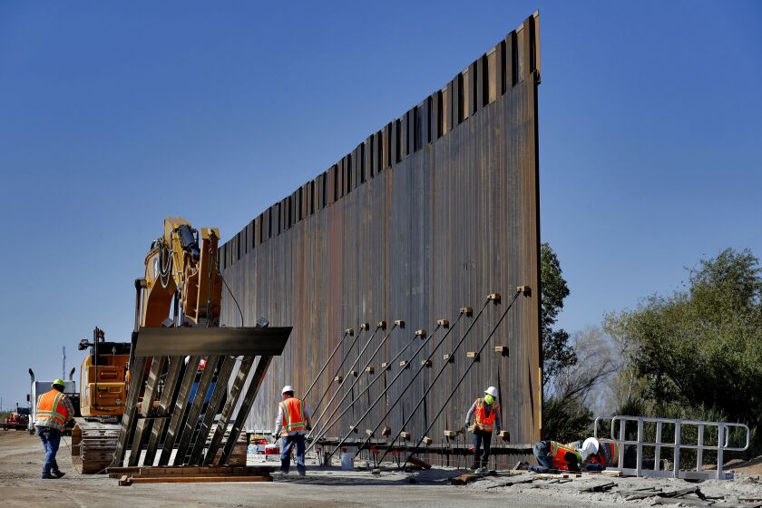 FILE - In this Sept. 10, 2019 file photo, government contractors erect a section of Pentagon-funded border wall along the Colorado River in Yuma, Ariz. The White House says construction of the U.S.-Mexico border wall will move forward after a federal appeals court ruling that frees up construction money. The 2-1 ruling on Wednesday halted a federal judge’s ruling in December that had prevented the government from spending $3.6 billion diverted from 127 military construction projects to pay for 175 miles of border wall. (AP Photo/Matt York)