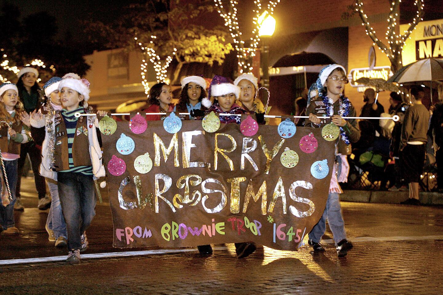 Members of a local Brownie Troop wave to the crowds during the annual Montrose Christmas Parade in Montrose on Saturday, December 1, 2012.