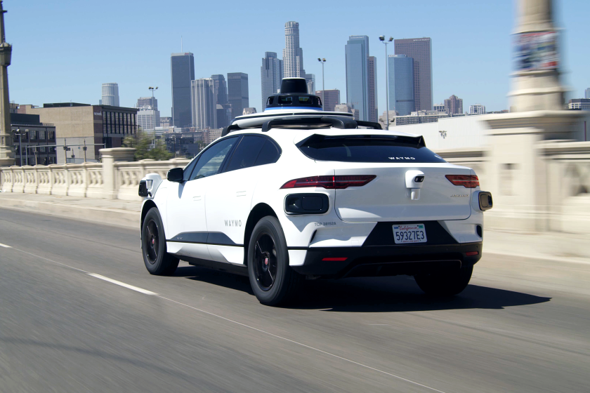 A white electric Jaguar I-Pace outfitted with Waymo full self-driving technology in Los Angeles.