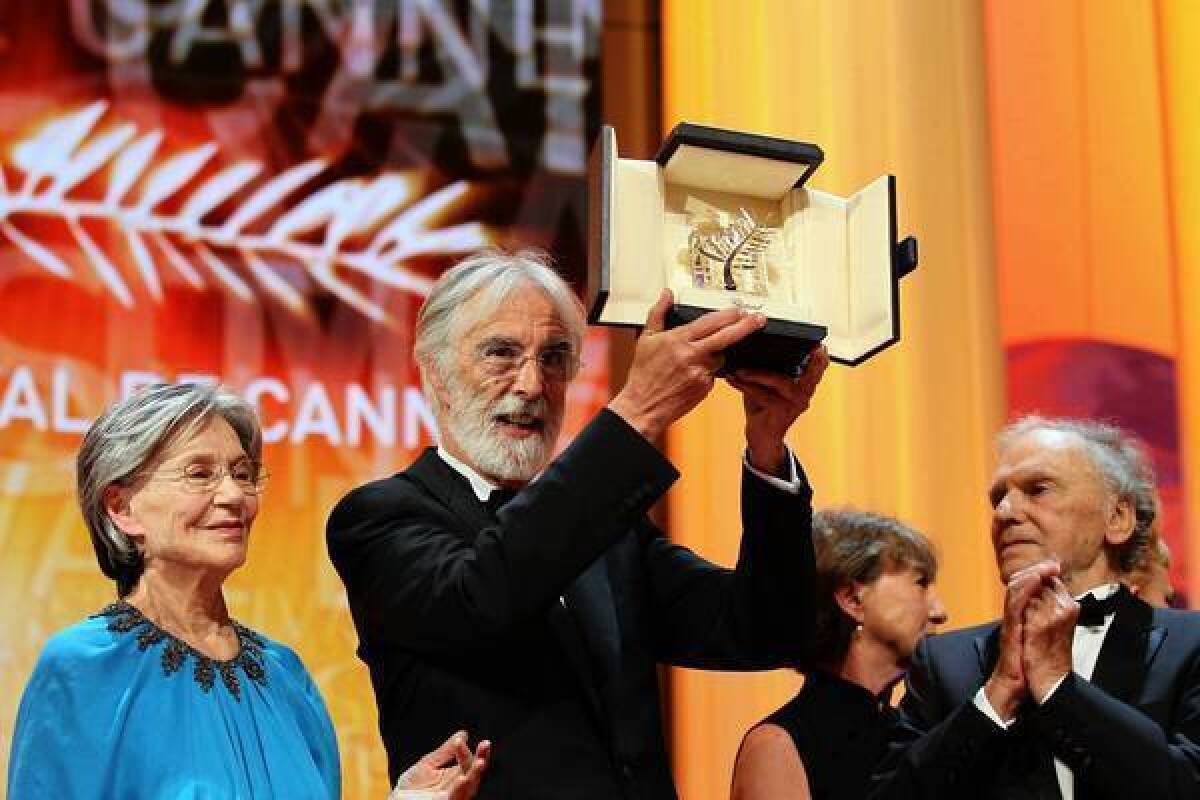 Austrian director Michael Haneke, center, raises his trophy as he poses with French actors Emmanuelle Riva, left, and Jean-Louis Trintignant after being awarded with the Palme d'Or for his film "Amour" during the closing ceremony of the 65th Cannes film festival on May 27.