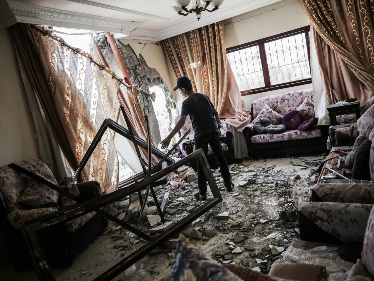 A Palestinian man stands amid the rubble of his home, which was damaged in an Israeli airstrike in Gaza City.
