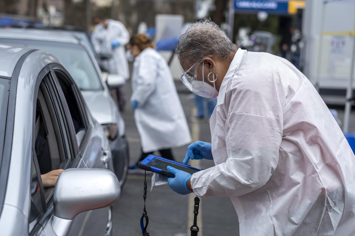 A woman in a white coat is testing for COVID-19 at a drive-through event