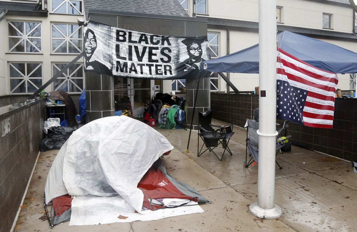 Members of Black Lives Matter continue their encampment Tuesday outside the Minneapolis Police Department's Fourth Precinct after the shooting death of Jamar Clark by a police officer during a struggle over the weekend.
