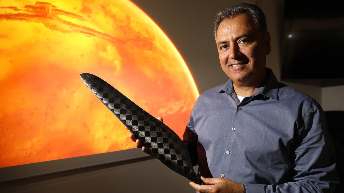 Wahid Nawabi, chief executive of AeroVironment Inc., holds a scale model of one of the composite blades that will be used to propel NASA's Jet Propulsion Laboratory Mars Helicopter through the thin Martian atmosphere.