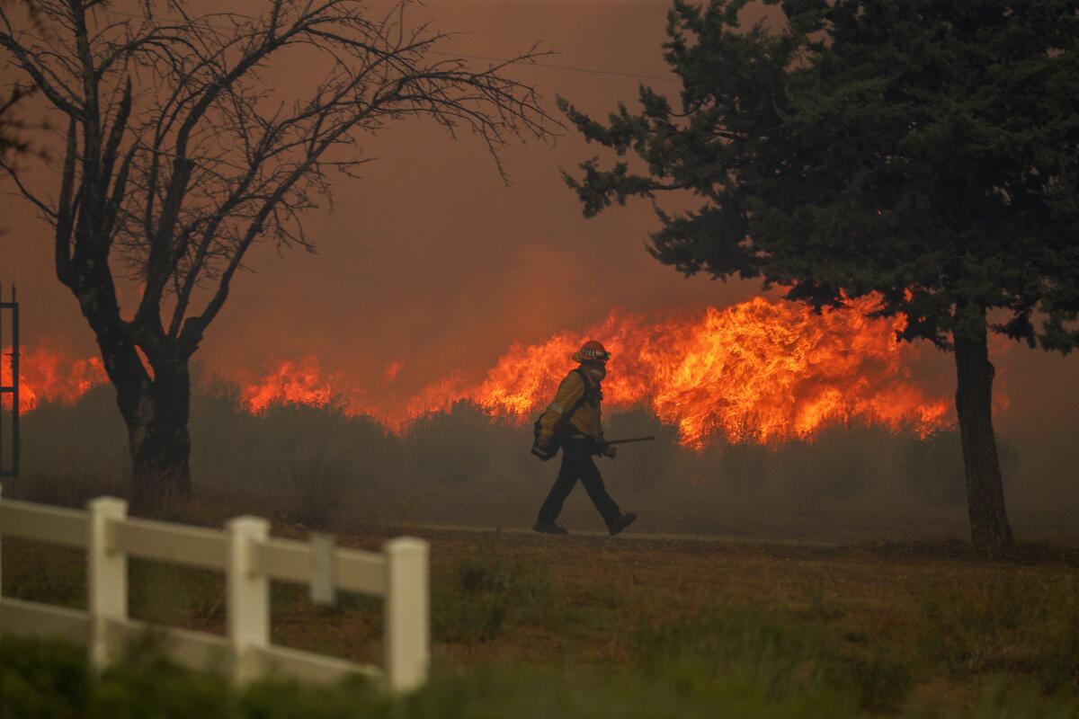 A crew works on Cima Mesa Road in Little Rock, Calif., on Sept. 18 as the Bobcat fire jumps the road, threatening structures.