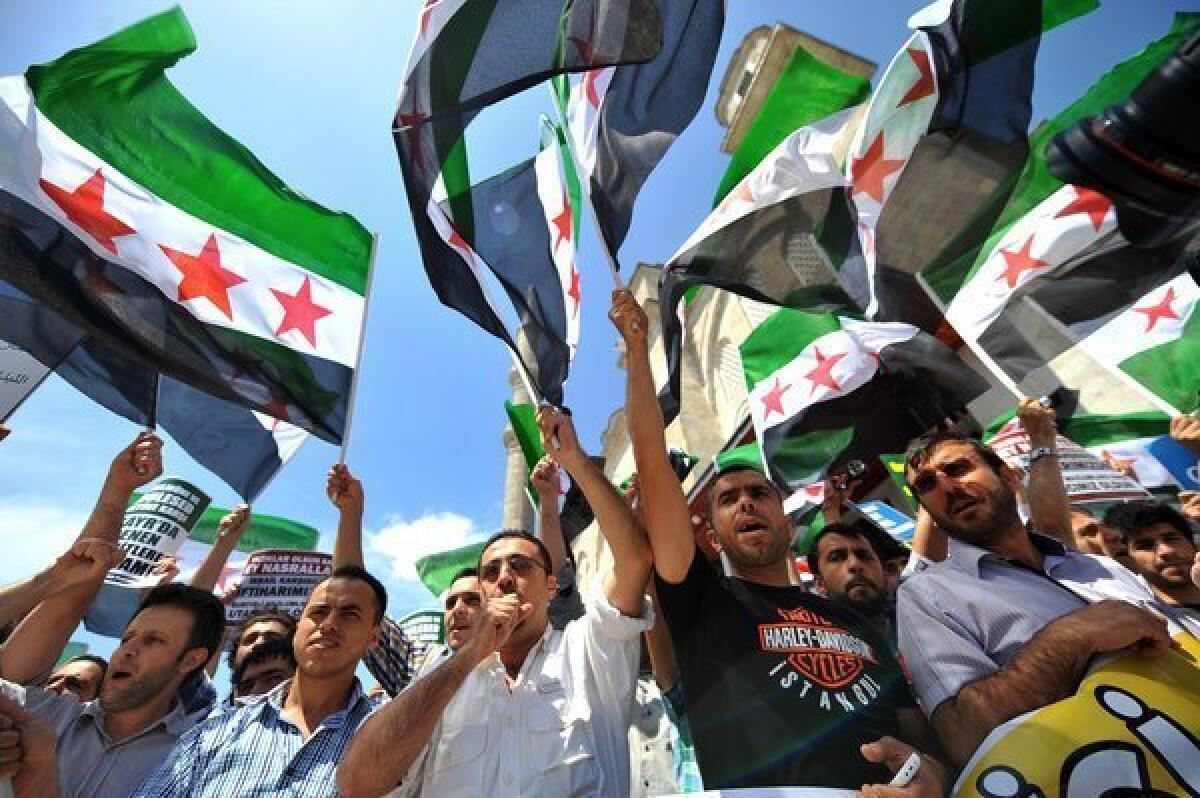Turkish Muslim protesters wave Free Syria's flags during a demonstration held in front of the Fatih mosque in Istanbul on Friday.