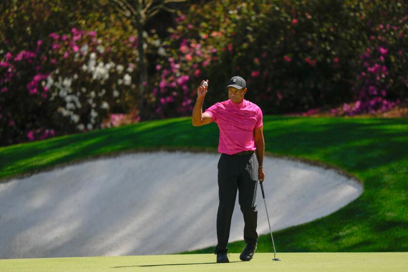 Tiger Woods holds up his ball after a birdie on the 13th hole during the first round.