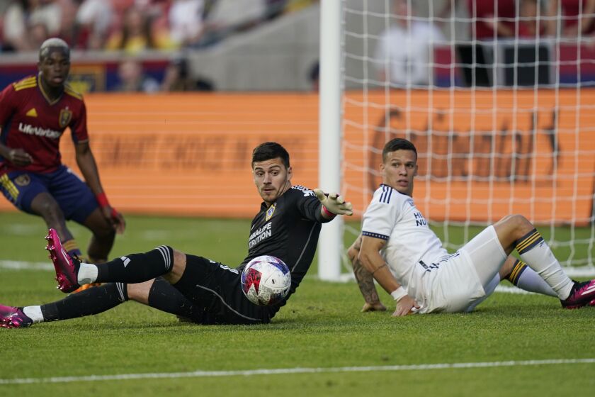 LA Galaxy goalkeeper Jonathan Bond, center, makes a save as teammate Lucas Calegari, right, and Real Salt Lake forward Carlos Andrés Gómez, left, look for the ball during the first half of an MLS soccer match Wednesday, May 31, 2023, in Sandy, Utah. (AP Photo/Rick Bowmer)