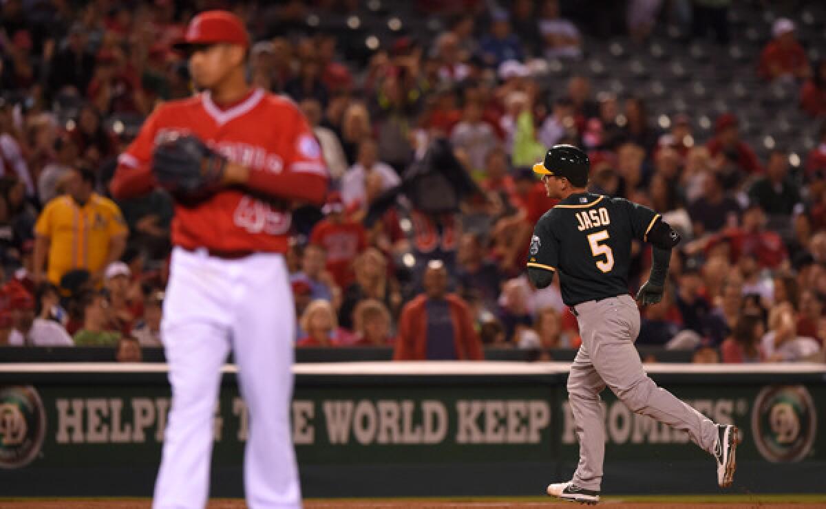 Oakland Athletics pinch hitter John Jaso, right, rounds third after hitting a two-run home run off Angels closer Ernesto Frieri, left, during the ninth inning of the Angels' 3-2 loss Monday.