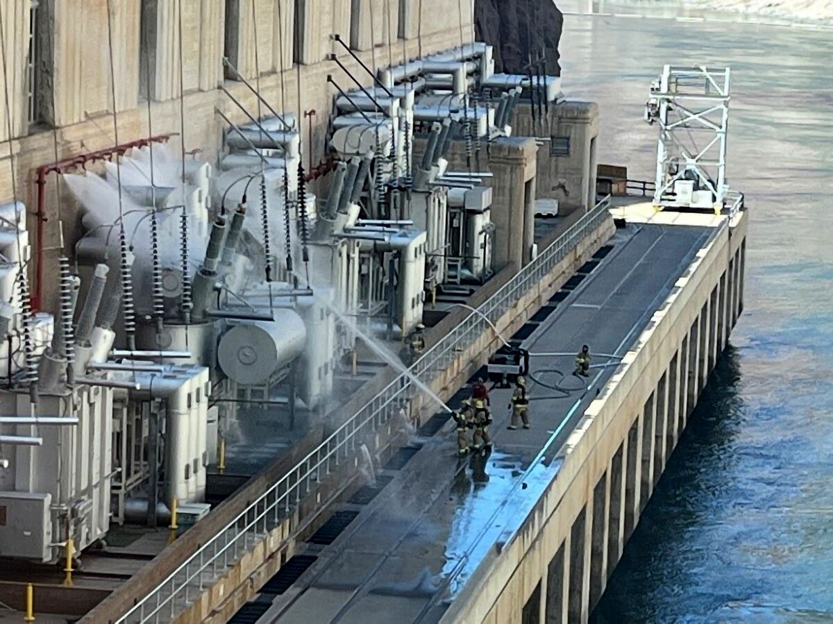 In this image provided by the U.S. Bureau of Reclamation, firefighters extinguish a fire at the Hoover Dam that borders Nevada and Arizona on Tuesday, July 19, 2022, near Boulder City, Nev. The agency said no one was injured. (U.S. Bureau of Reclamation via AP)
