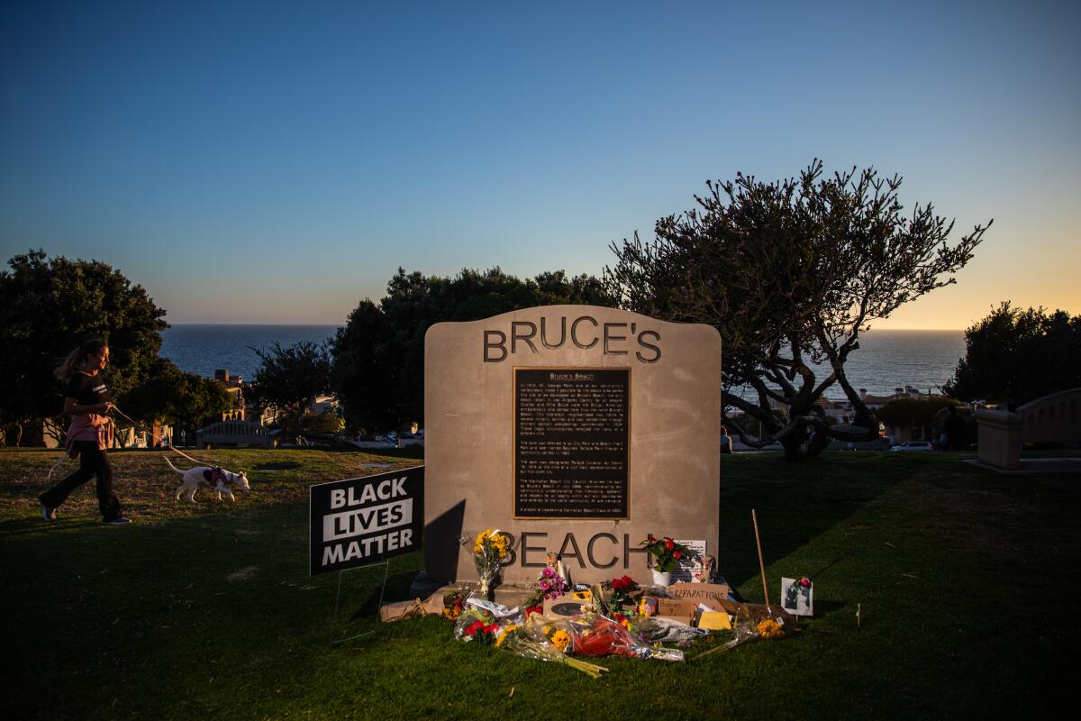 A plaque at Bruce's Beach adorned with flowers