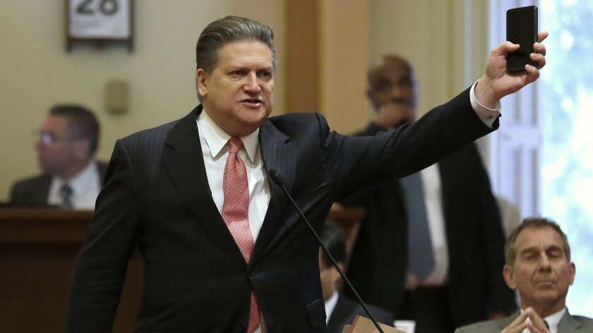 State Sen. Bob Hertzberg (D-Van Nuys) displays his smartphone as he urges lawmakers to approve a data privacy bill during a Senate floor session in June 2018.