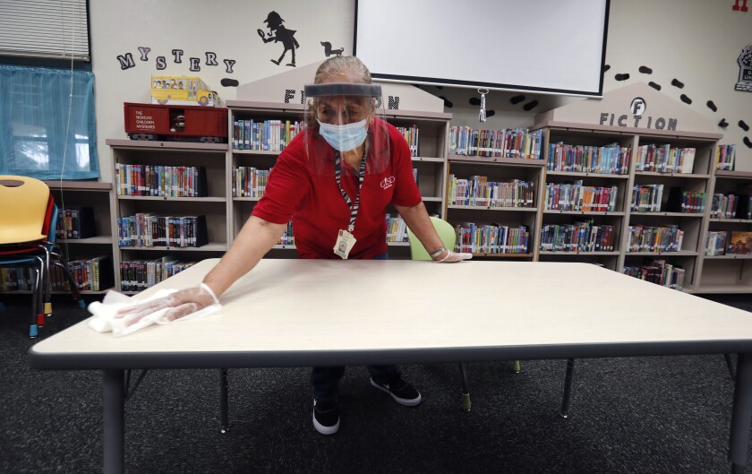 A custodian cleans a library at an elementary school in Rowlett, Texas.