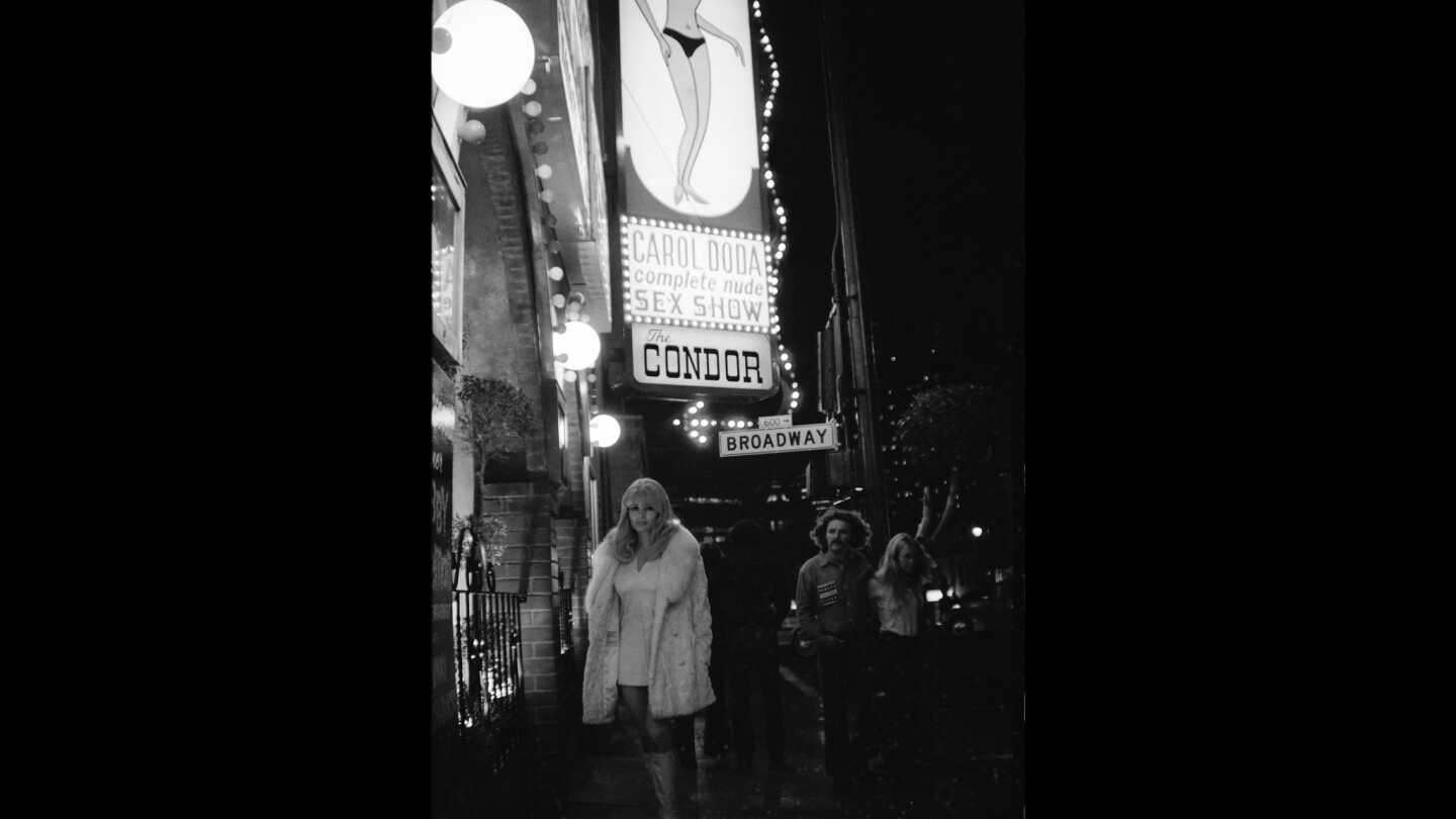 Carol Doda poses under a marquee bearing her name and likeness outside the Condor Club in the 1970s. She became a cocktail waitress at 14.