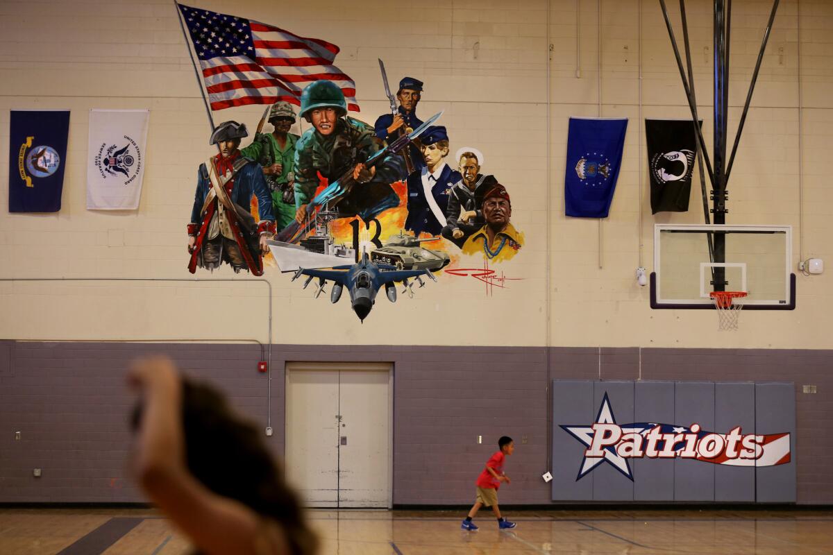 The city of Gallup honored the war hero by naming a school, Hiroshi Miyamura High School, after him. A mural in the gymnasium bears his image, center. (Rick Loomis / Los Angeles Times)