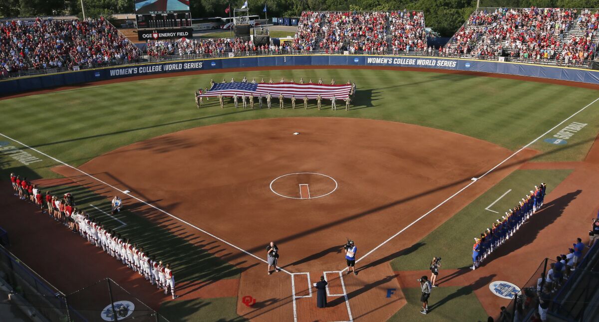 FILE - A large flag is unfurled in the outfield before the second game of the best-of-three championship series between Florida and Oklahoma in the NCAA Women's College World Series in Oklahoma City, in this Tuesday, June 6, 2017, file photo. The NCAA has reached a delicate moment: It must decide whether to punish states that have passed laws limiting the participation of transgender athletes by barring them from hosting its softball and baseball tournaments. (AP Photo/Sue Ogrocki, File)
